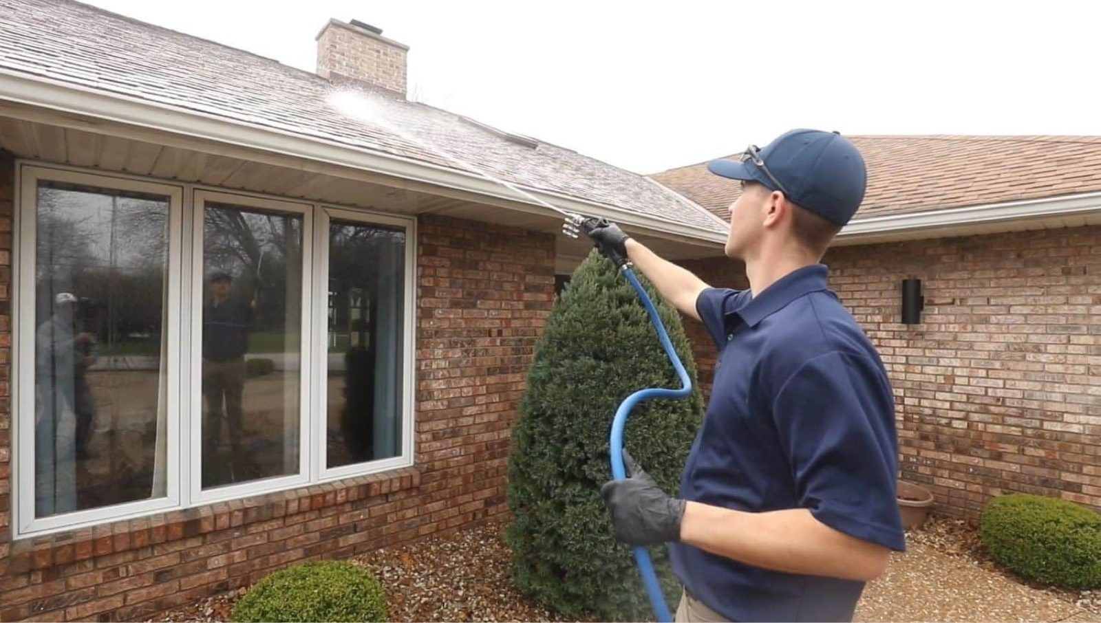 Todd soft washing a brick home