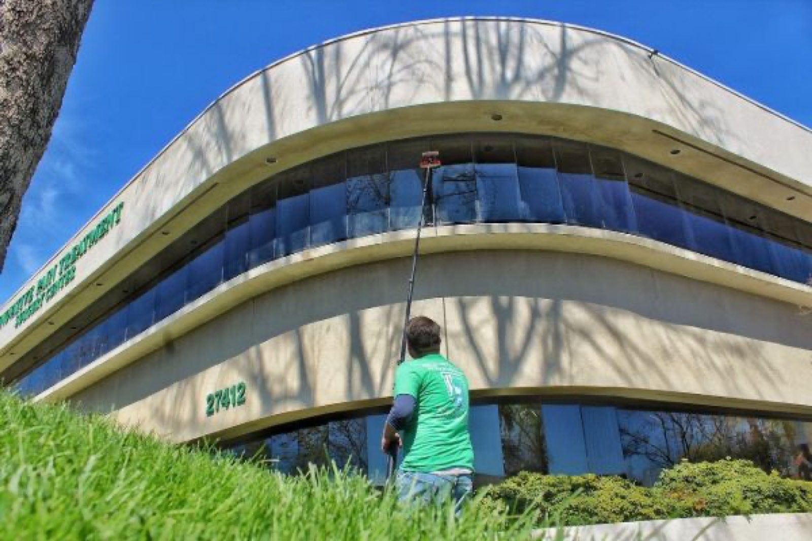 Technician cleaning a curved office building
