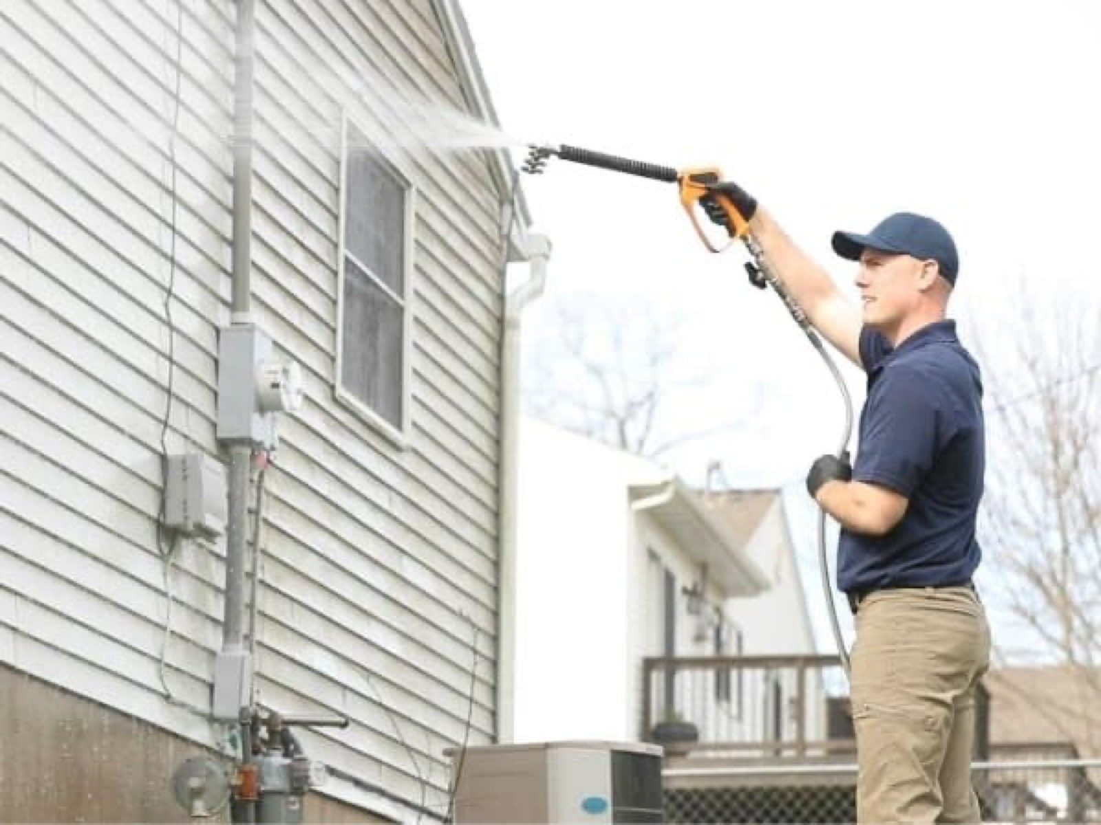 Restore technician soft washing vinyl siding on a LaGrange home